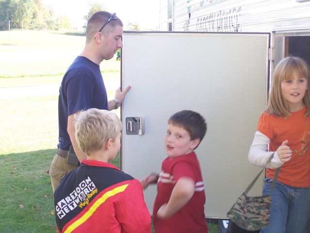 Potsdam FF Jerrid Lavoie assists children our the back door of the trailer.